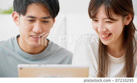 Young men and women using tablet computers Young men and women using tablet computers 87210295