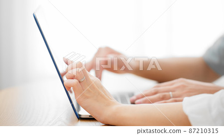 Young men and women looking at laptops Young men and women looking at laptops 87210315