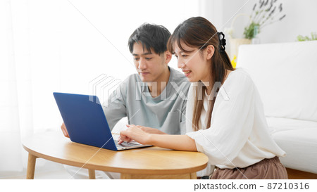 Young men and women looking at laptops Young men and women looking at laptops 87210316