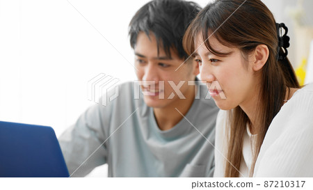 Young men and women looking at laptops Young men and women looking at laptops 87210317