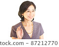 A meeting image of a smiling middle-aged woman who is fashionable and raises one hand 87212770