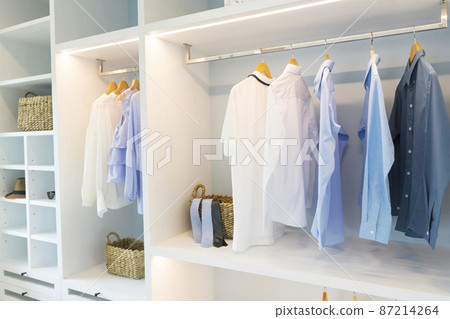 A Large White Built-in Wardrobe Stocked With Clothing, Shoes and Accessories. Walk-in closet, Dressing Room. 87214264