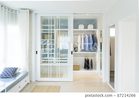 A Large White Built-in Wardrobe Stocked With Clothing, Shoes and Accessories. Walk-in closet, Dressing Room. A Large White Built-in Wardrobe Stocked With Clothing, Shoes and Accessories. Walk-in closet, Dressing Room. 87214266
