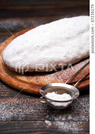 Traditional Christmas stollen cake with marzipan and dried fruit isolated on wooden background Traditional Christmas stollen cake with marzipan and dried fruit isolated on wooden background 87216279