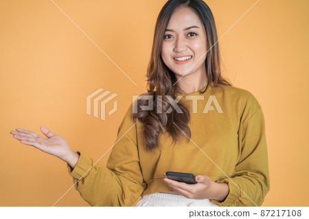 woman using mobile phone with presenting copyspace on the palm 87217108