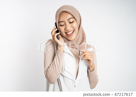 happy asian woman making a call using a cell phone 87217617
