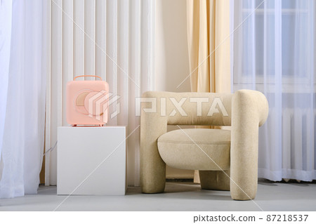 Mobile mini refrigerator near cozy armchair, portable fridge Mobile mini refrigerator near cozy armchair, portable fridge 87218537