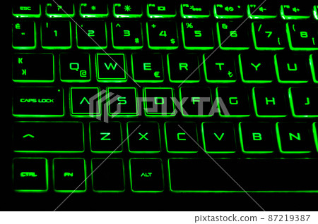A black color laptop and Q keyboard green light detail A black color laptop and Q keyboard green light detail 87219387
