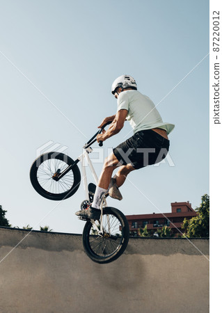 young man extreme jumping with bicycle 87220012