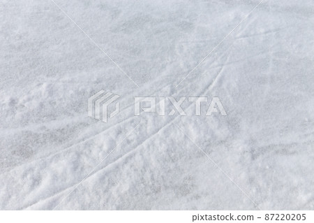 Ice background with marks from skating and hockey, blue texture of rink surface with many scratches Ice background with marks from skating and hockey, blue texture of rink surface with many scratches 87220205