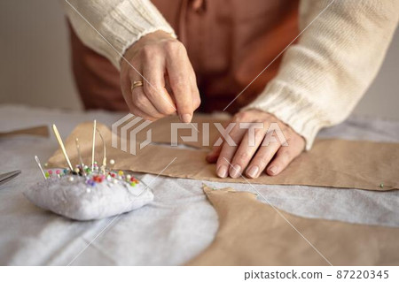 tailor woman using needle thread sew 87220345