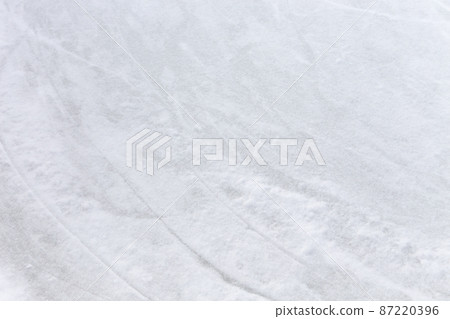 Ice background with marks from skating and hockey, blue texture of rink surface with many scratches Ice background with marks from skating and hockey, blue texture of rink surface with many scratches 87220396