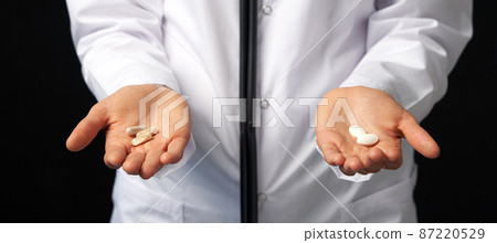 Cropped view of female Doctor holding in hands Pills to choose. Difficult Choice between drugs. Placebo drugs concept. Healthcare concept. Cropped view of female Doctor holding in hands Pills to choose. Difficult Choice between drugs. Placebo drugs concept. Healthcare concept. 87220529