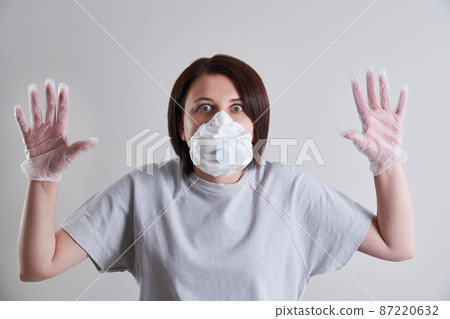 Young woman wearing face mask for protection from coronavirus over grey background with copy space 87220632