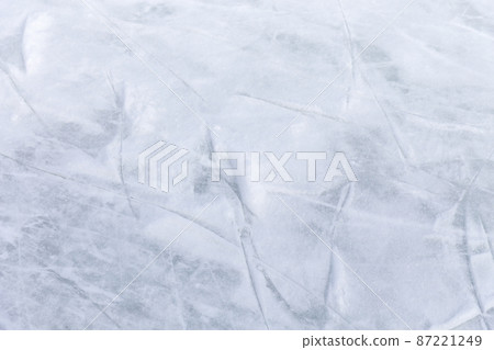 Ice background with marks from skating and hockey, blue texture of rink surface with many scratches Ice background with marks from skating and hockey, blue texture of rink surface with many scratches 87221249