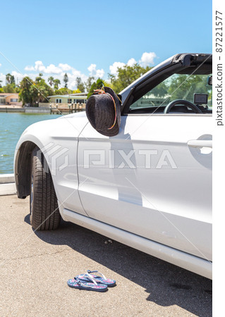 Convertible car with hat hanging on a mirror Convertible car with hat hanging on a mirror 87221577