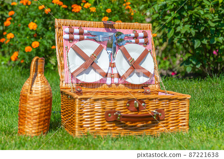 Picnic basket on green sunny lawn in the park 87221638