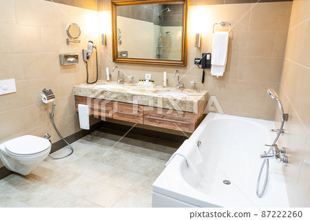 Luxury bathroom with brown tiles and two sinks Luxury bathroom with brown tiles and two sinks 87222260