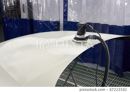 Auto mechanic buffing and polishing car in auto repair shop with orbital polisher, basic layer cleaning Auto mechanic buffing and polishing car in auto repair shop with orbital polisher, basic layer cleaning 87223582