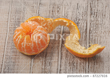 tangerine with peeled peel on a wooden background tangerine with peeled peel on a wooden background 87227816