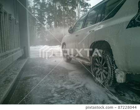 white offroad car stand on carwash winter 87228044