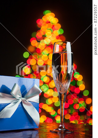 champagne and gift against bokeh lights 87229357