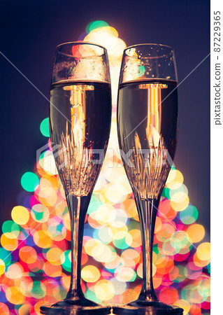 champagne glasses against christmas bokeh lights 87229365