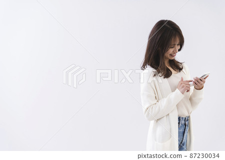 Woman using a smartphone 87230034