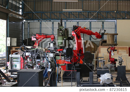Robotics arm in the metal factory plant . it's performing routine servicing of the welding robotics units equipment. Robotics arm in the metal factory plant . it's performing routine servicing of the welding robotics units equipment. 87230815
