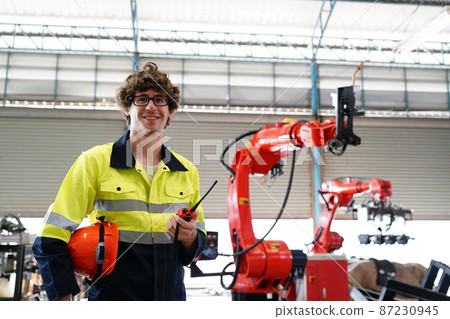 engineer checking control panel and teaching new Automatics robot arm and operating control machine in factory. 87230945