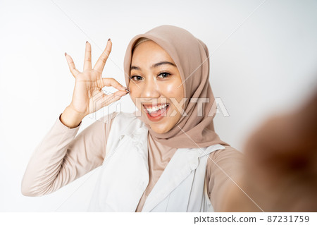 woman in hijab holding a smart phone for selfie woman in hijab holding a smart phone for selfie 87231759