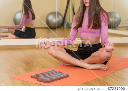 practice of standing on nails. Close-up of a yoga man standing on a sadhu board with sharp nails. Wooden sadhu board with nails for sadhu practice 87231900