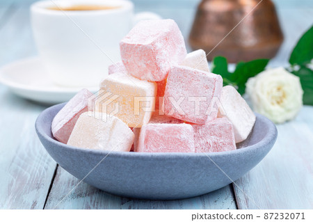 Turkish delight or lokum confection rose and lemon flavored with cup of coffee and cezve, closeup Turkish delight or lokum confection rose and lemon flavored with cup of coffee and cezve, closeup 87232071