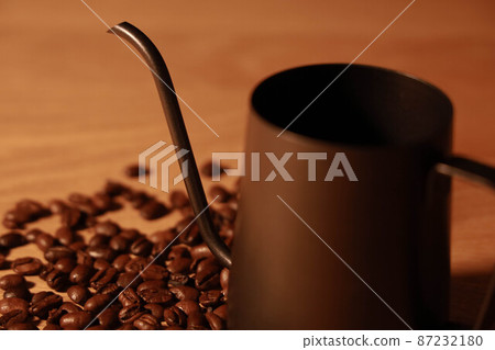 Coffee beans scattered on the table and fashionable drip pods Coffee beans scattered on the table and fashionable drip pods 87232180