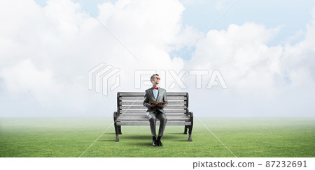Young businessman or student studying the science in summer park Young businessman or student studying the science in summer park 87232691