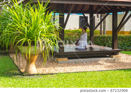 Woman in gazebo practicing yoga in Thailand in Asia Woman in gazebo practicing yoga in Thailand in Asia 87232906