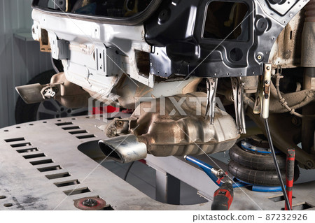 Car standing on a lift platform for repair in auto service shop Car standing on a lift platform for repair in auto service shop 87232926