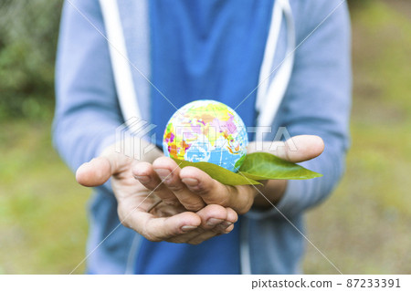 man holding sphere palm hand with leaf 87233391