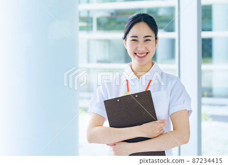 Smiling medical worker in white coat working in hospital Smiling medical worker in white coat working in hospital 87234415