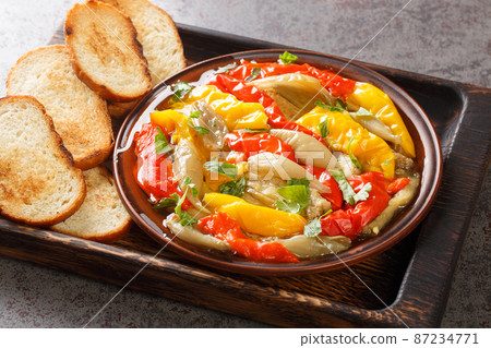 Spanish food Escalivada consists of roasted eggplant, onion and bell peppers with olive oil and minced garlic closeup in the wooden board. Horizontal Spanish food Escalivada consists of roasted eggplant, onion and bell peppers with olive oil and minced garlic closeup in the wooden board. Horizontal 87234771