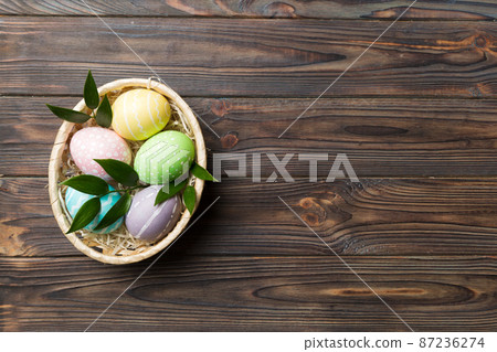 Multi colors Easter eggs in the woven basket on colored background . Pastel color Easter eggs. holiday concept with copy space Multi colors Easter eggs in the woven basket on colored background . Pastel color Easter eggs. holiday concept with copy space 87236274