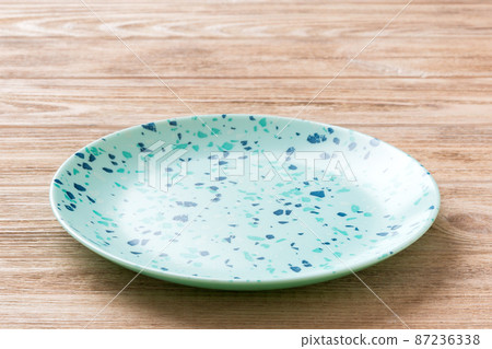 Perspective view of empty blue plate on wooden background. Empty space for your design Perspective view of empty blue plate on wooden background. Empty space for your design 87236338