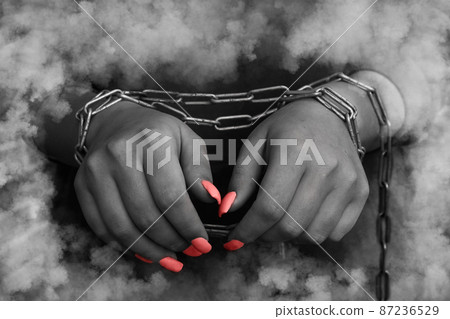 Woman's hands tied with a chain - discolored conceptual photo 87236529
