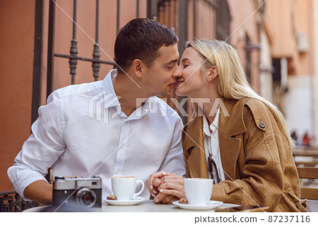 Portrait of kissing couple sitting in cafe 87237116