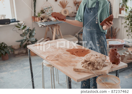 Ceramist woman preparing clay to make pottery pieces in studio Ceramist woman preparing clay to make pottery pieces in studio 87237462