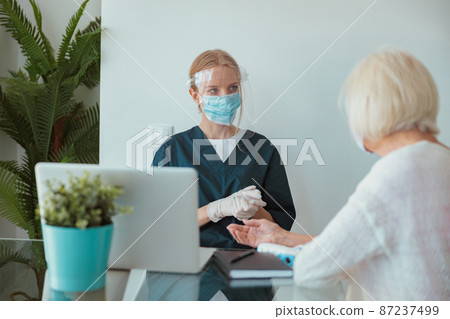 Young nurse talking to elderly woman at home Young nurse talking to elderly woman at home 87237499