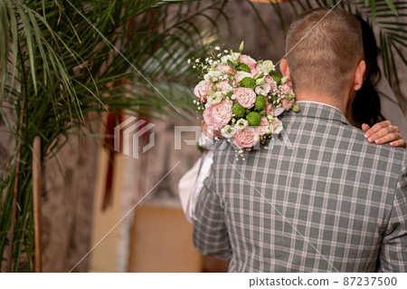 the groom hugged the bride. wedding bouquet in the hands of the bride. High quality photo the groom hugged the bride. wedding bouquet in the hands of the bride. High quality photo 87237500