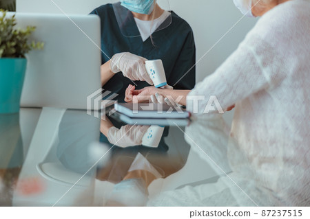 Healthcare specialist checking elderly patient at home Healthcare specialist checking elderly patient at home 87237515