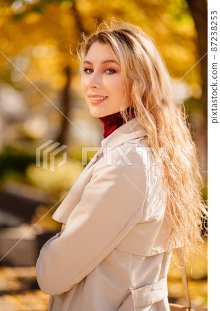 a portrait beautiful blonde in a coat on an autumn street. a portrait beautiful blonde in a coat on an autumn street. 87238253