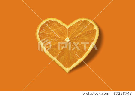 Fresh cut orange and heart shape are fashionable. Orange background. 87238748